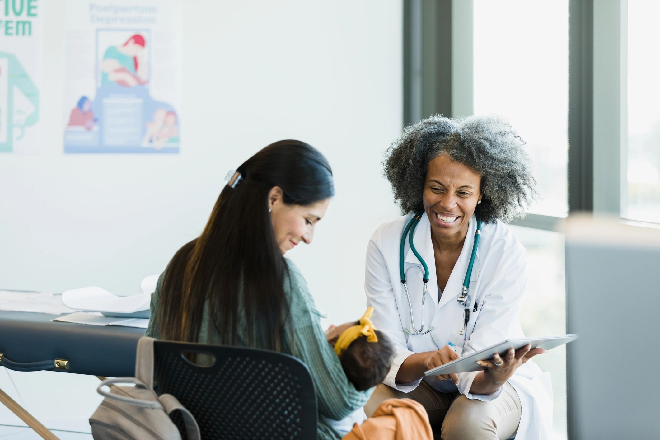 Mother and healthcare professional smiling during a baby care discussion