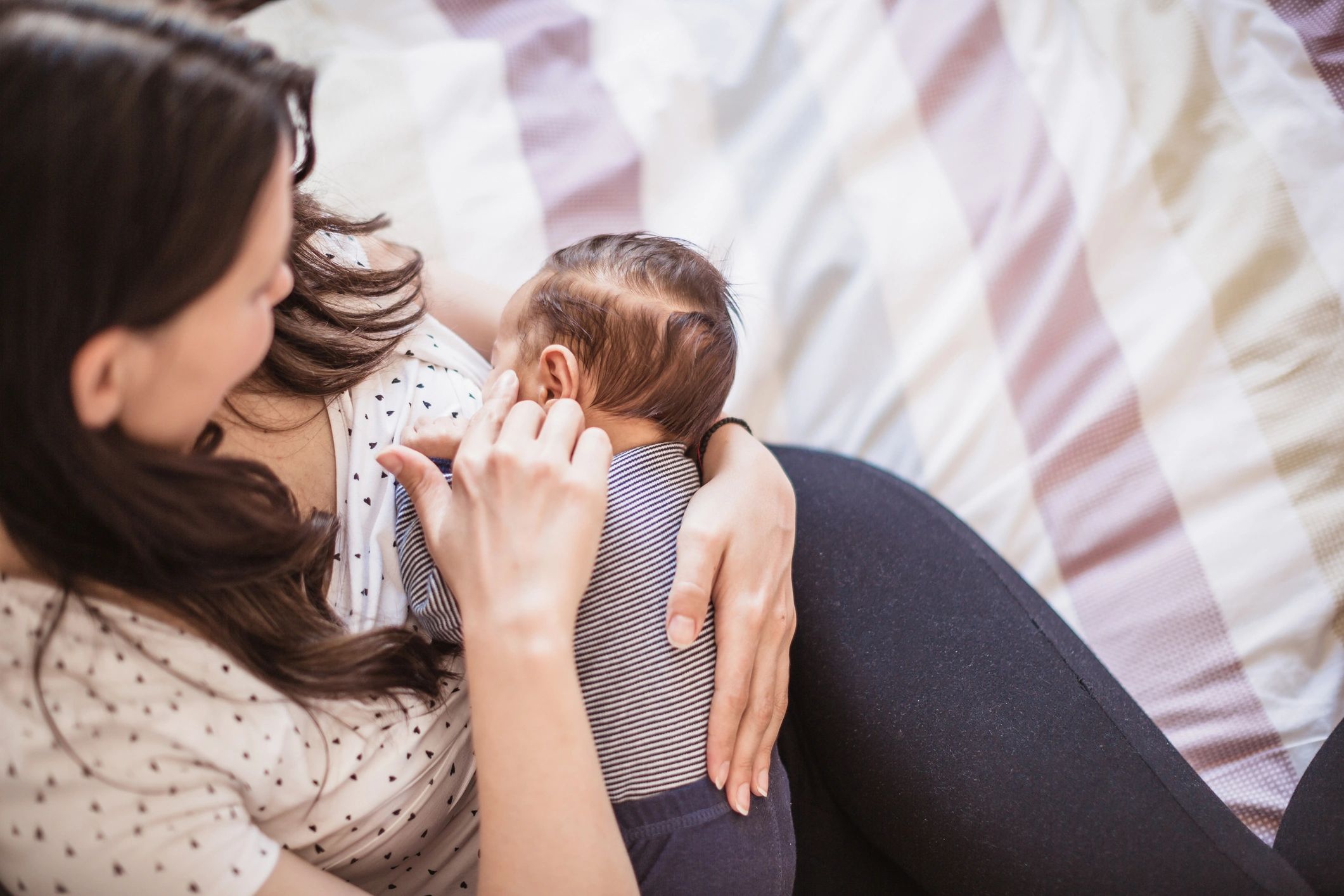 Mother breastfeeding baby at home in a calm setting