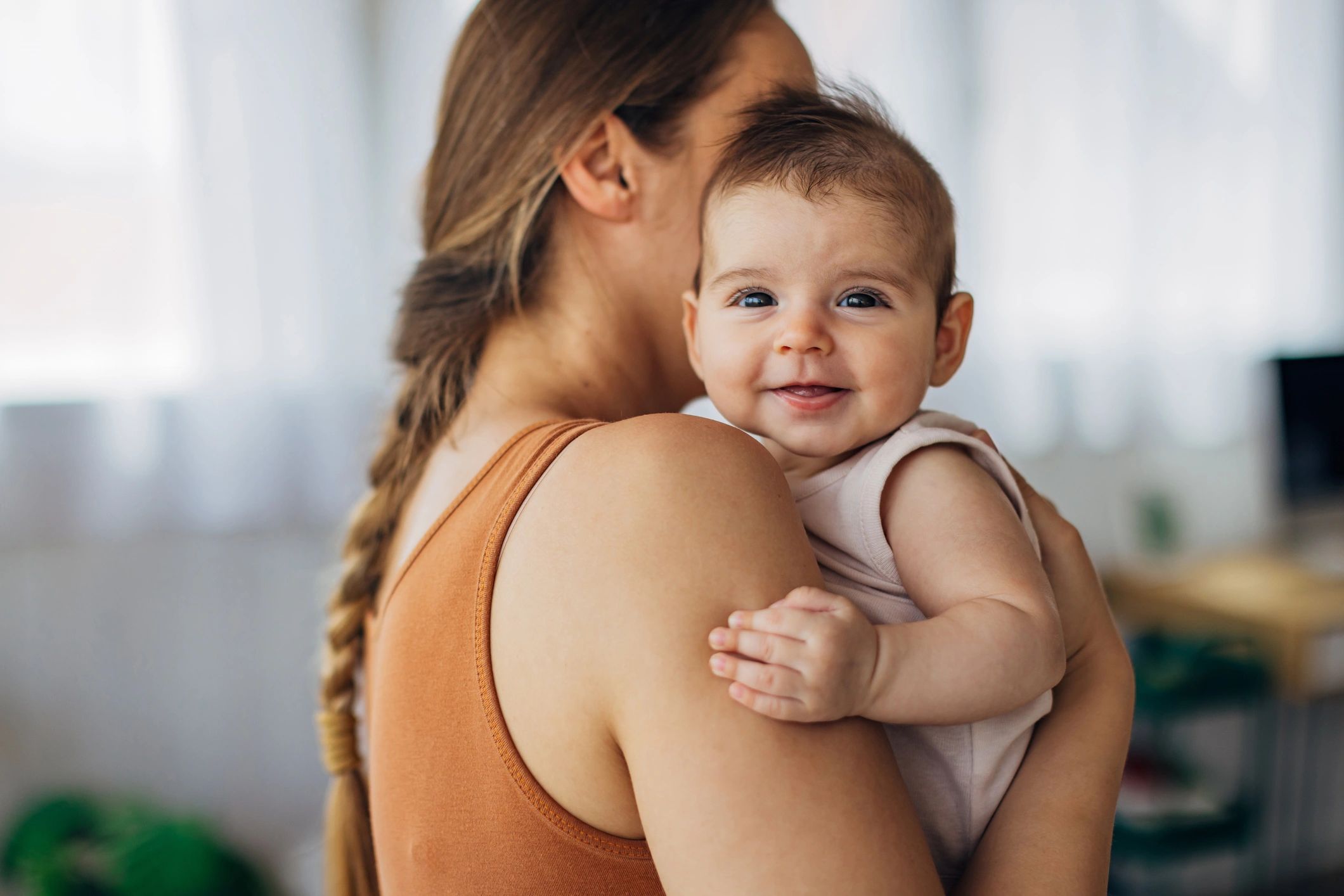 Parent holding baby with a calm smile